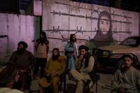 En grupp talibaner i samtal framför en väggmålning i Kabul. Arkivbild.