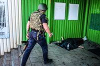 En polis beskådar en kroppen av en kvinna som dödats av en klusterbomb i en småstad nära Sievjerodonetsk, enligt AP. Gatustriderna i Sievjerodonetsk påminner om de som tidigare rasade i den sönderbombade staden Mariupol.