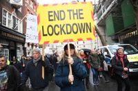 Människor deltar i en demonstration mot nedstängningar och vaccinering i Londonområdet Westminister den 14 december.