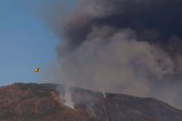 Brandbekämpningsplan dumpar vatten över branden i Sierra Bermeja-bergen i Spanien.
