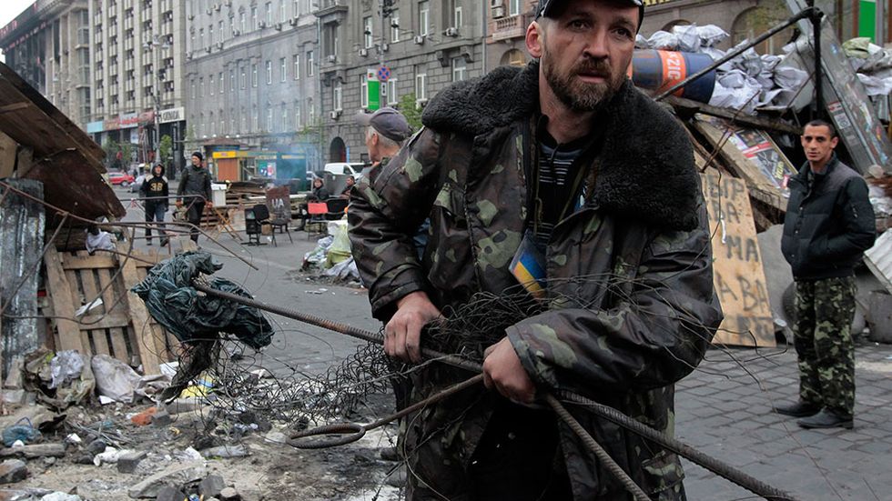 Frivilliga medborgare i Kiev bär bort barrikader på en gata som leder till Självständighetstorget. Pro-ryska protester har pågått i flera städer i landet.