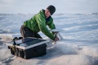 Brian Rougeux från New York University monterar en GPS-sändare på en glaciär på Grönland för att kunna mäta hur den smälter.