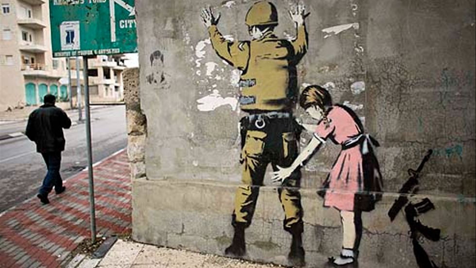 Den lilla flickan som kroppsvisiterar en israelisk soldat hör till en av Banksys målningar i Betlehem.