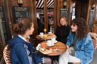 "En känsla av frihet". Så beskriver filmstudenten Lola Guilbaud (till höger) möjligheten att åter avnjuta en frukost på kafé. Här är hon tillsammans med Ines Piquet och Emma Hugon på kaféet Les Petites vid Place de la Contrescarpe i Paris.