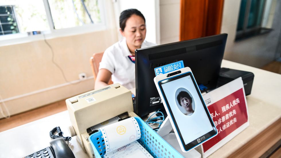 En kvinna i Kina får sitt ansikte scannat.