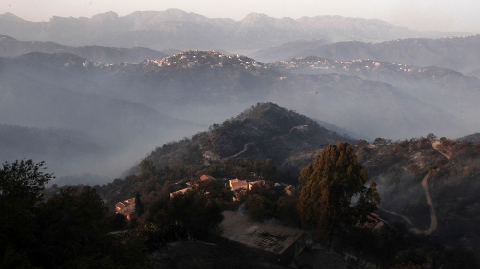 Rök över branddrabbade berg i kabyliska regionen i Algeriet. Arkivbild.