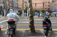 En polis i skyddsdräkt bevakar coronatestningen av invånare i västra Shanghai som gick in i lockdown 1 april.