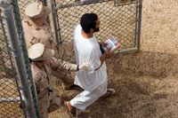 En fånge eskorteras av två vakter på Camp Delta 4-delen på Guantanamo.