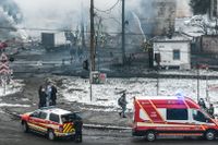 Räddningspersonal försöker släcka en brand efter ryska bombningar i Kiev.