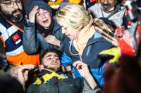 Räddningsarbetare och anhöriga samlade runt en 17-åring som räddades efter 94 timmar i rasmassorna i Gaziantep.