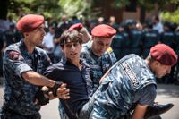 En demonstrant bärs bort av kravallpolis under demonstrationer i Armeniens huvudstad i måndags.
