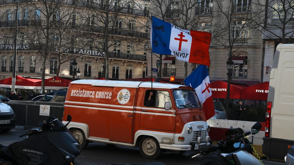 En demonstrant kör längs med Champs-Élysées i Paris för att protestera mot vaccinpasset.