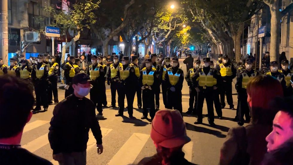 Kinesisk polis blockerar vägen till delar av den kinesiska staden Shanghai där demonstranter samlades under söndagen.