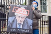 En demonstrant utanför 10 Downing Street håller upp en skylt som kallar premiärministern Boris Johnson för ”skyldig”. På onsdagen släpptes tjänstemannen Sue Grays rapport om festerna på Downing Street under Storbritanniens nedstängningar. 