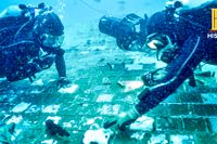 Marinbiologen Mike Barnette och vrakdykaren Jimmy Gadomski vid vrakdelen de fann på Atlantens botten. Bilden togs från en faktaserie som kommer att visas på tv.