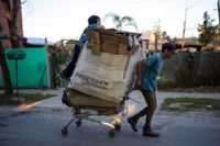 Jonathan Palacios och hans då åttaåriga son som också heter Jonathan, drar en kundvagn med kartonger de hoppas kunna sälja i Buenos Aires i en bild från augusti.