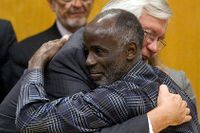 Försvararen Robert Young kramar James Bain som släpptes ur fängelset efter att ha suttit 35 år, felaktigt dömd för kidnappning och våldtäkt.