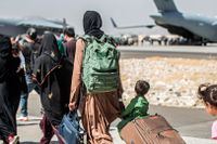 Familjer evakueras från flygplatsen i Kabul.