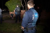 Australisk polis vaktar en misstänkt under razzian i Sydney den 18 september.