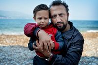 Maher Fanosh med sin son Mohamed, 3 år, på Samos strand.