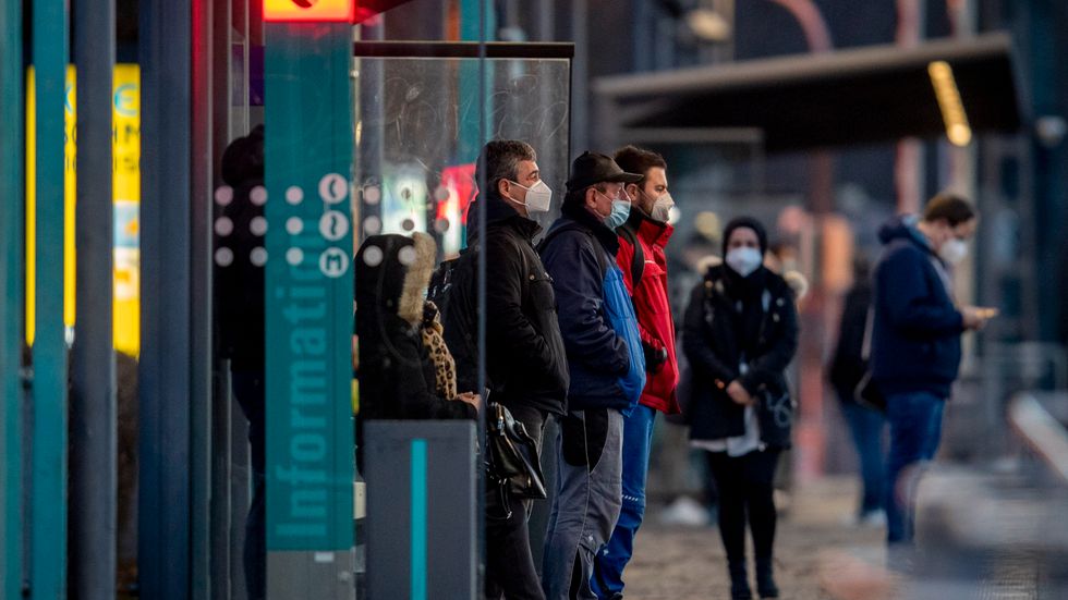 Tyskar i munskydd väntar på tunnelbanan i Frankfurt am Main.