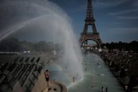 Invånare i Frankrikes huvudstad Paris svalkar sig i fontänerna vid Trocadéro i närheten av Eiffeltornet. Bilden är från den 28 juni när värmerekordet 46 grader Celsius uppmättes i Héraultdepartementet i södra Frankrike.