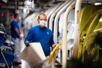Coronakrisen har slagit hårt mot tysk industri, här ses en anställd med munskydd på en VW-fabrik. Arkivbild.