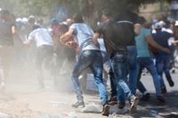 Palestinier flyr från tårgas i Jerusalems gamla stad, fredagen den 28 juli. 