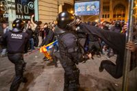 En demonstrant sparkar en polis under lördagens protester i Barcelona. 