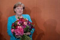 Den tyska förbundskanslern Angela Merkel tar emot en blombukett på sin födelsedag.