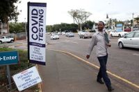 Sydafrika befinner sig i en fjärde smittovåg som drivs av den nya coronavirusvarianten omikron. På bilden en man som går förbi en teststation i Durban i Sydafrika.