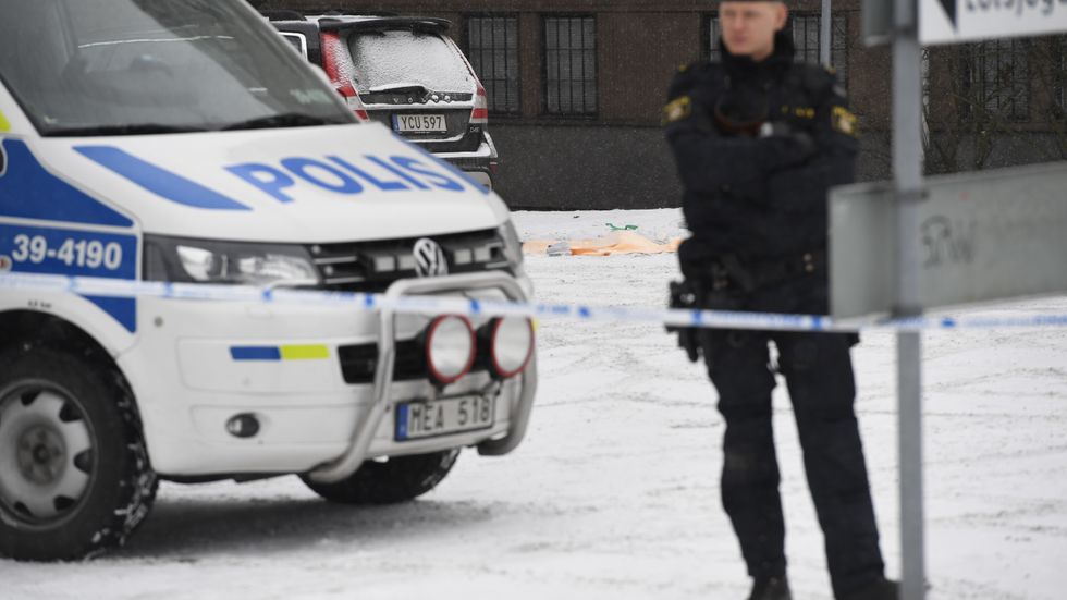 En polis vaktar avspärrningen där en man knivskars till döds i Hallonbergen.