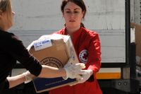 Röda korset-medarbetare distribuerar nödhjälp under en översvämning i Bosnien, 2014.