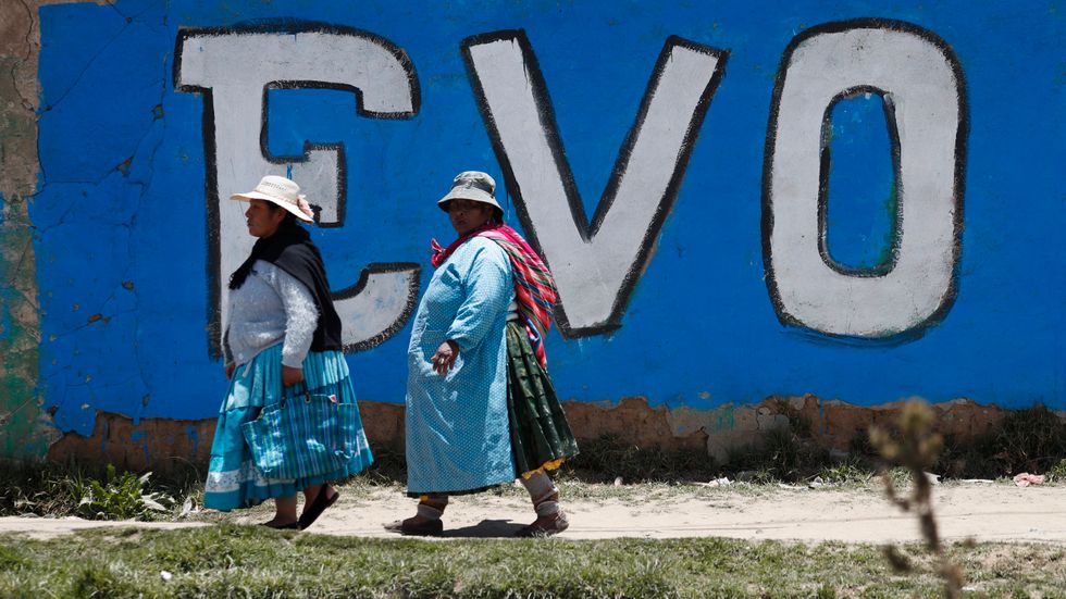Anhängare till ex-presidenten Evo Morales passerar en väggmålning i El Alto, en förstad till huvudstaden La Paz där det bor många människor från Bolivias ursprungsbefolkning. Bilden är tagen den 20 november.