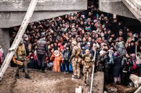 I staden Irpin nära Kiev har broar sprängts, här syns civila gömma sig under en förstörd bro.