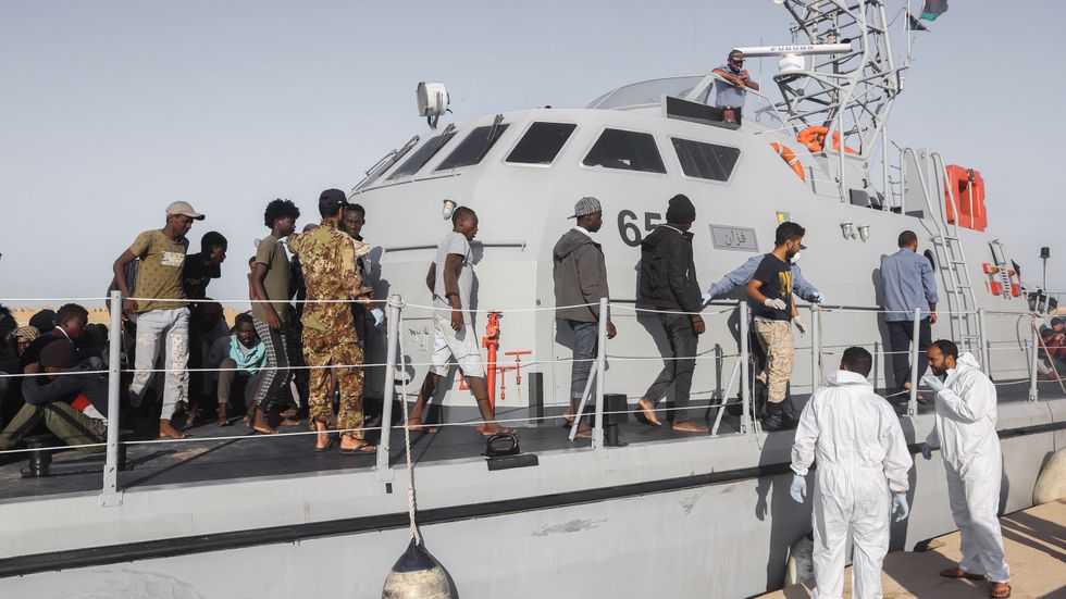 MIgranter som går iland i staden Khom från ett av den libyska kustbevakningens fartyg. Arkivbild