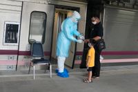 En sjukvårdare testar syrenivåerna på en covidsmittad som ska åka med tåg från Bangkok till sin hemstad. Syftet är att minska trycket på sjukvården i huvudstaden.
