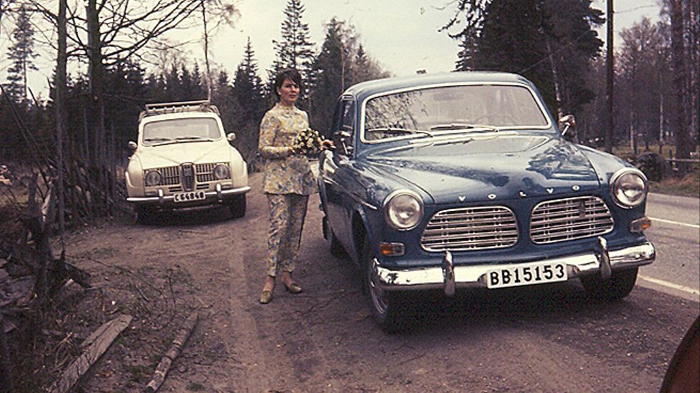 Det är vår 1969 och SvD-läsaren Lars Rystedt var 14 år. Han är ute på sedvanlig bilutflykt med mamma och pappa. De tar en paus och det tickar från den varma motorn i den splitternya Volvo Amazonen – där mamman poserar framför kameran med blombukett i handen. Förstulet, avundsjukt får den dimvita Saab 95:an se sig besegrad denna dag av den medelhavsblå Amazonen.
Spana in det lilla märket till höger i grillen, ”B20” står det, en statusmarkör av mått 1969. Volvos B18-motor hade fått stryka på foten för nya B20 med två liters cylindervolym, enkel Stromberg-förgasare och 82 hästkrafter.
Det var brytningstid. Lars ville hellre vara hemma och lyssna på Tio i topp. För Amazonen blev året efter, 1970, den sista årsmodellen, igenkännbar på sina nackstöd.