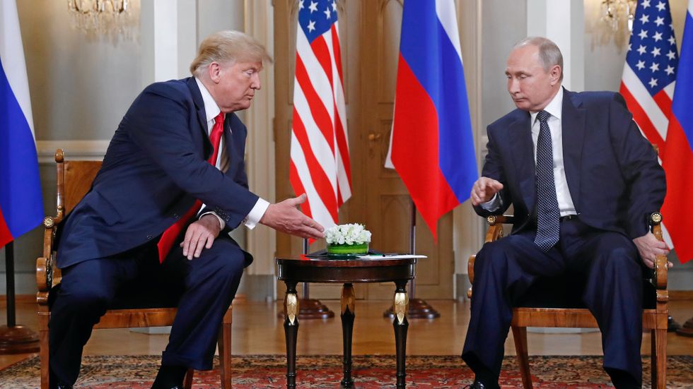  U.S. President Donald Trump, left, reaches out for a handshake with Russian President Vladimir Putin at the beginning of a meeting at the Presidential Palace in Helsinki, Finland, Monday, July 16, 2018 