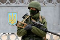 Soldat i omärkt uniform utanför en ukrainsk militärbas på Krim våren 2014.