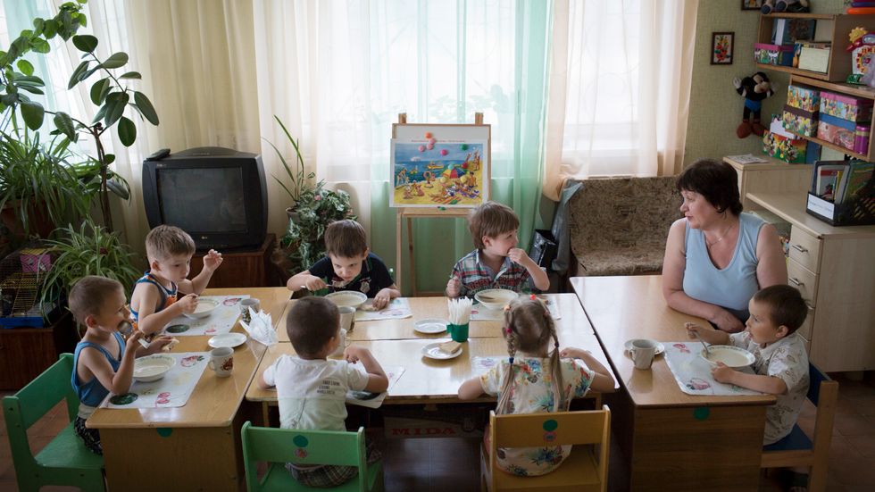 Dagisläraren Galina Kvatj äter lunch med sin dagisgrupp för 4-åringar.