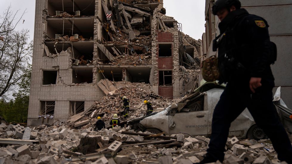 Räddningspersonal vid en byggnad som delvis förstördes i den ryska attacken mot staden Tjernihiv på onsdagen.
