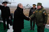 Rysslands president Vladimir Putin skakar hand med befälhavaren för det västra området i närheten av S: t Petersburg. Ryska trupper har haft en stor övning.