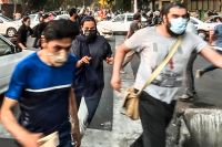 Människor flyr polisen under protester i Teheran den 19 september 2022.