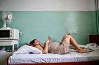 En gravid kvinna tittar på sin telefon på en avdelning på mödravårdskliniken i västra Zaporizjzja. Bilden togs den 1 september.