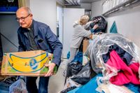 Kyrkoherde Anders Litzinger och Tetiana Petrushka hjälper till att sortera hjälp till Ukraina i Sjömanskyrkans lokaler i Göteborg.