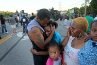 Fergusonbon Terrell Williams El kramar sin dotter Sharell. Bredvid står hans fru Shamika Williams och dottern Tamika. Familjen känner sig upprörda och skakade av mordet och responsen efter folkprotesten utanför ortens polisstation.