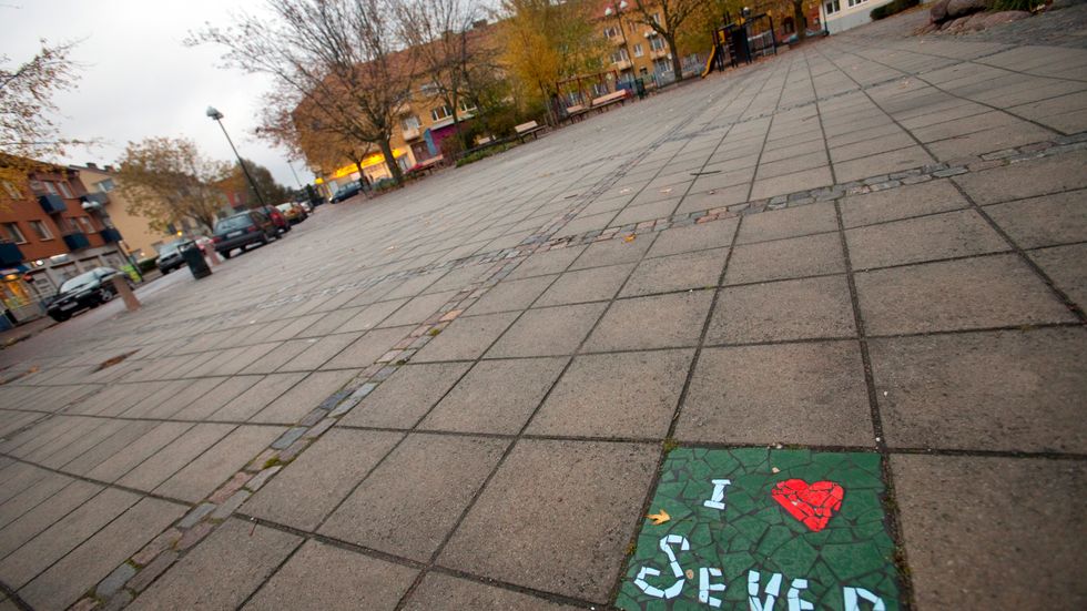 En färggrann kakelplatta med texten "I love Seved" bryter av mot de grå markplattorna i bostadsområdet Seved (Södra Sofielund) i Malmö. Arkivbild.