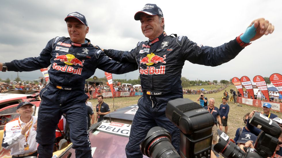 Carlos Sainz (till höger) och kartläsaren Lucas Cruz firar segern i årets Dakarrally.