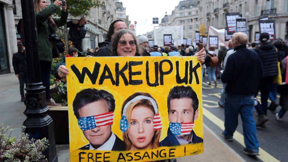 En demonstrant protesterar mot de rättsförhandlingar som äger rum i London under onsdagen och torsdagen. Storbritanniens högsta domstol ska pröva en överklagan från USA om att få Julian Assange utlämnad.